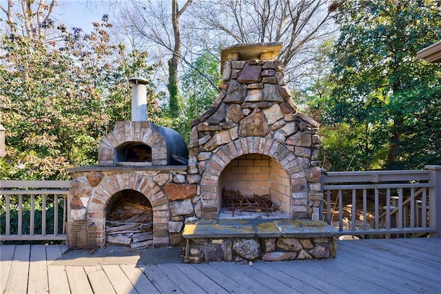 wooden terrace featuring an outdoor stone fireplace