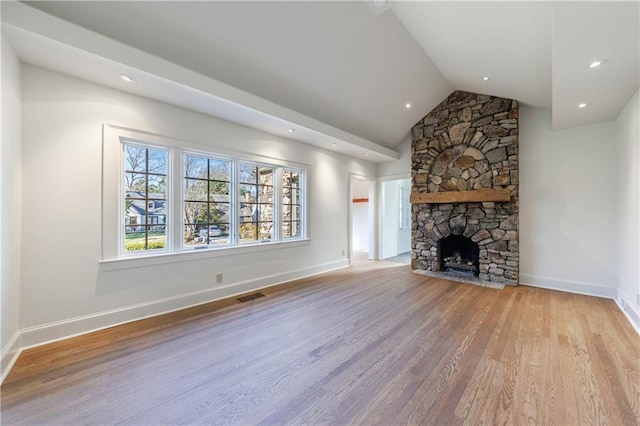 unfurnished living room with a fireplace, light hardwood / wood-style flooring, and lofted ceiling