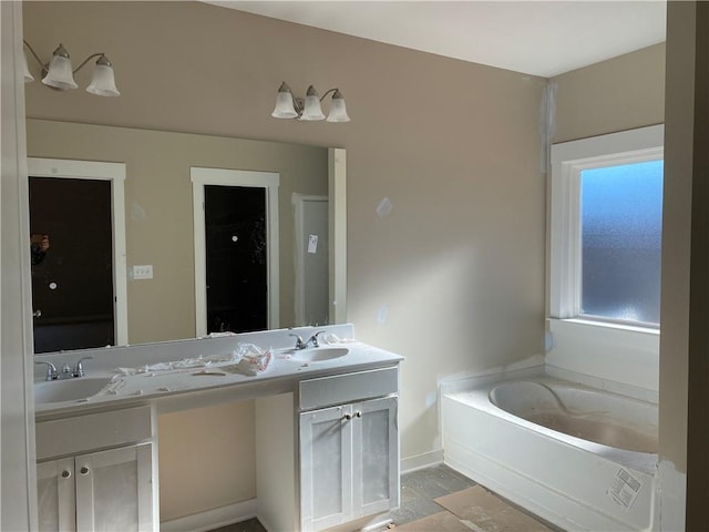 258 Westminster Ct, Winder, GA 30680 - bathroom with double vanity, a garden tub, and baseboards