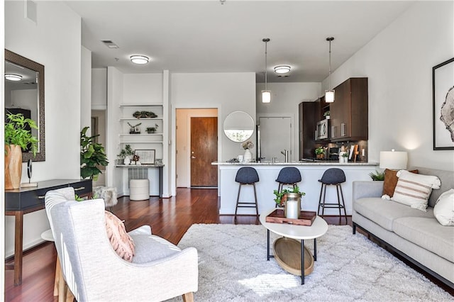 living room featuring built in features and dark hardwood / wood-style flooring