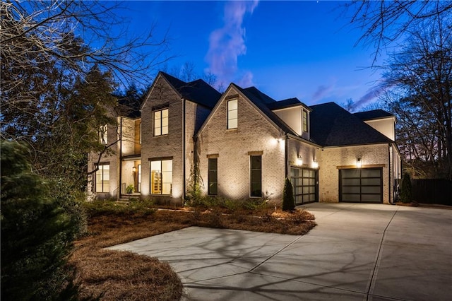 view of front facade featuring driveway, brick siding, and an attached garage