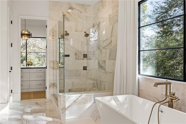 full bath featuring a sink, marble finish floor, a soaking tub, and a shower stall