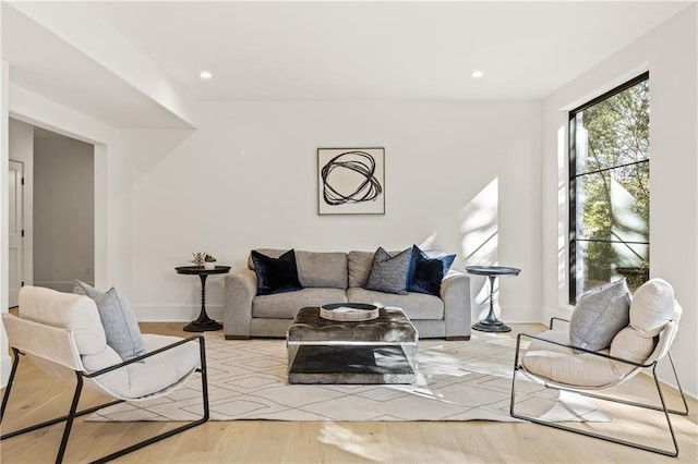 living area with light wood-style floors, recessed lighting, and baseboards