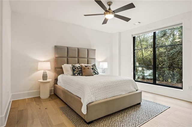 bedroom featuring light wood-type flooring, ceiling fan, and baseboards