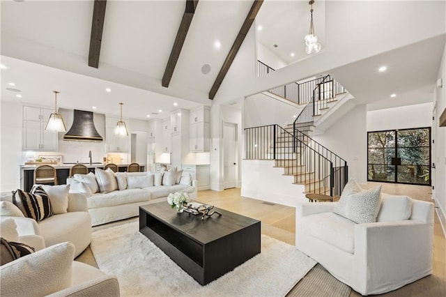 living room featuring recessed lighting, stairway, light wood-style flooring, high vaulted ceiling, and beamed ceiling