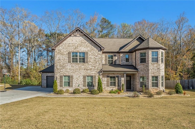 view of front facade featuring a front lawn, driveway, fence, brick siding, and an attached garage
