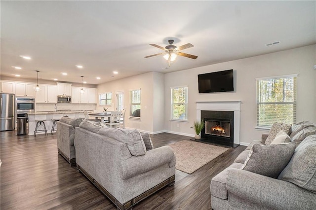 living room featuring a wealth of natural light, a ceiling fan, visible vents, and recessed lighting