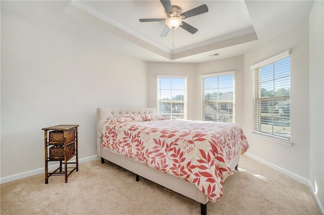bedroom with multiple windows, a tray ceiling, carpet, and crown molding