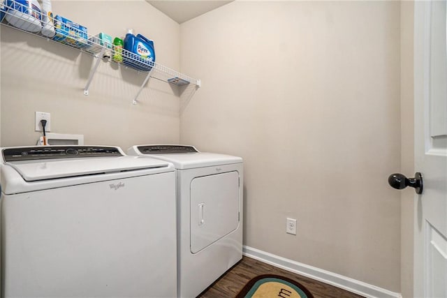 laundry room with washing machine and clothes dryer, dark wood-style flooring, laundry area, and baseboards