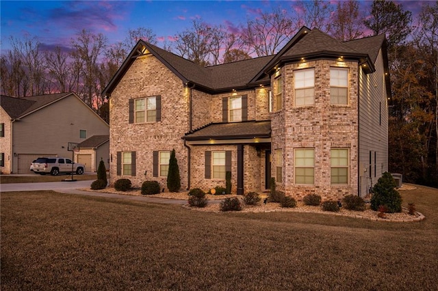 traditional-style home with a front lawn, brick siding, and central air condition unit