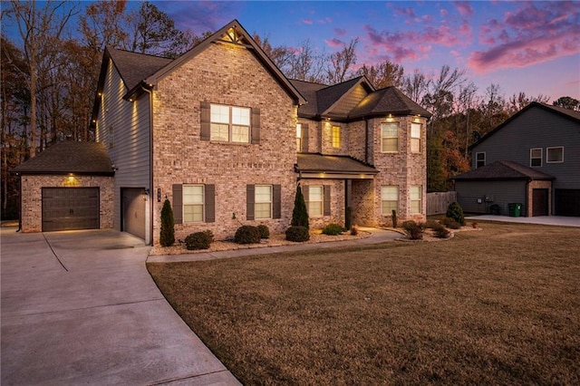 traditional-style home featuring a garage, a front lawn, brick siding, and concrete driveway