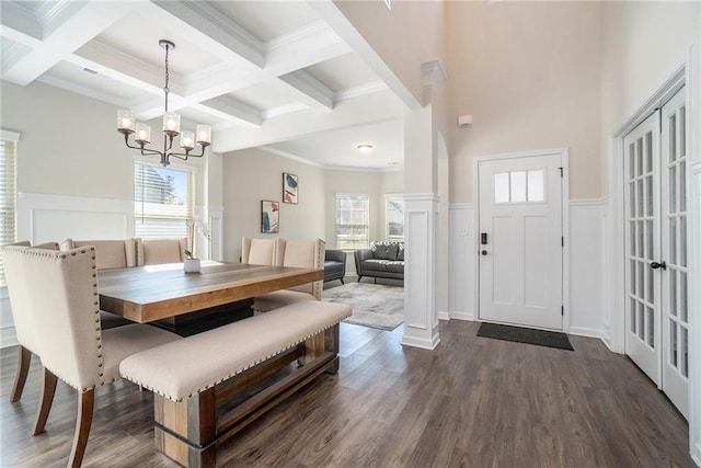 dining space with beamed ceiling, a decorative wall, a notable chandelier, and coffered ceiling