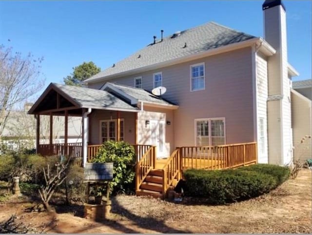 back of property featuring a deck and a chimney