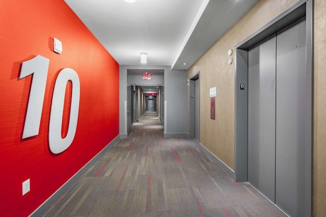 hallway featuring dark carpet and elevator