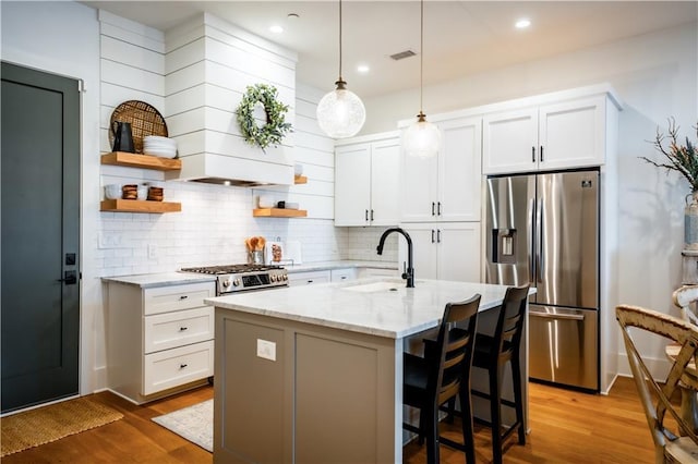 kitchen with stainless steel refrigerator with ice dispenser, a sink, open shelves, white cabinetry, and range