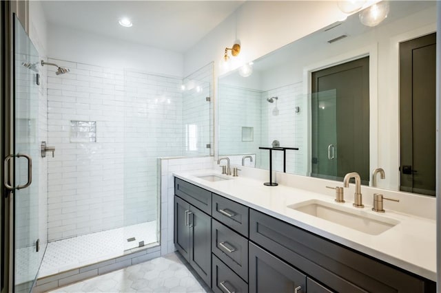 full bath with a shower stall, double vanity, visible vents, and a sink