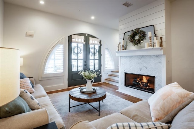 living room with a wealth of natural light, visible vents, french doors, and wood finished floors