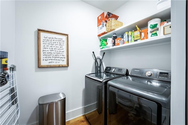 laundry room featuring baseboards, separate washer and dryer, wood finished floors, and laundry area