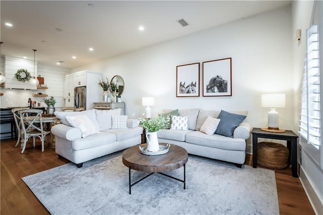 living area with recessed lighting, visible vents, and dark wood-type flooring