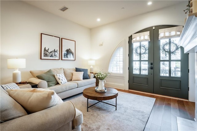 living area featuring recessed lighting, visible vents, wood finished floors, and french doors