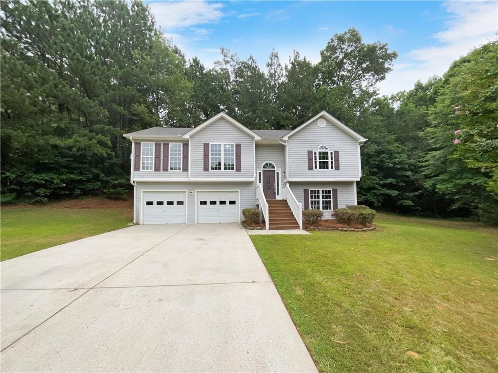 split foyer home featuring a garage and a front lawn