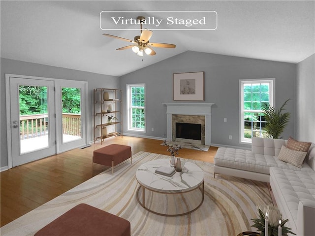 living room featuring a fireplace, light wood-type flooring, and a healthy amount of sunlight