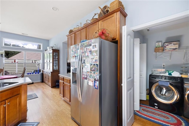418 Thaxton Ln, Woodstock, GA 30188 - kitchen with stainless steel refrigerator with ice dispenser, brown cabinets, light wood finished floors, washer and clothes dryer, and light countertops