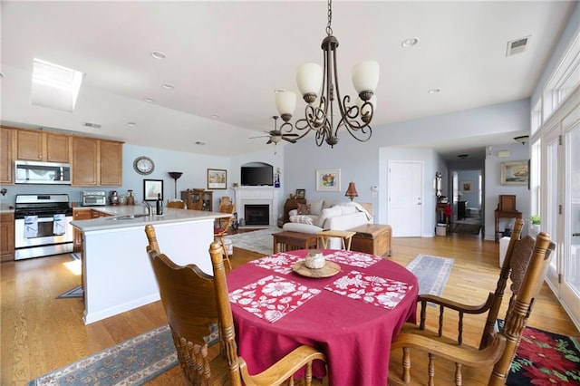 418 Thaxton Ln, Woodstock, GA 30188 - dining area featuring ceiling fan, light wood-style floors, a fireplace, a chandelier, and recessed lighting