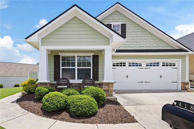 418 Thaxton Ln, Woodstock, GA 30188 - view of front of home featuring stone siding, a garage, driveway, and covered porch