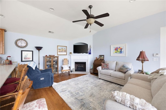 418 Thaxton Ln, Woodstock, GA 30188 - living area with a ceiling fan, a fireplace with raised hearth, wood finished floors, and vaulted ceiling