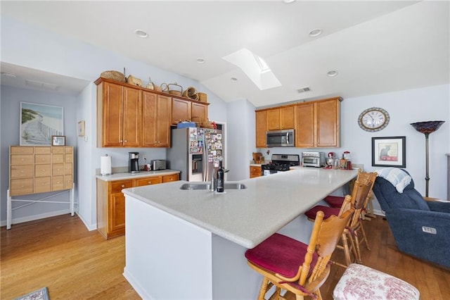 418 Thaxton Ln, Woodstock, GA 30188 - kitchen with stainless steel appliances, light wood-style flooring, brown cabinetry, light countertops, and lofted ceiling