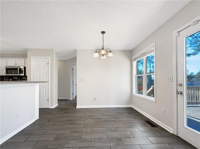 unfurnished dining area with a chandelier