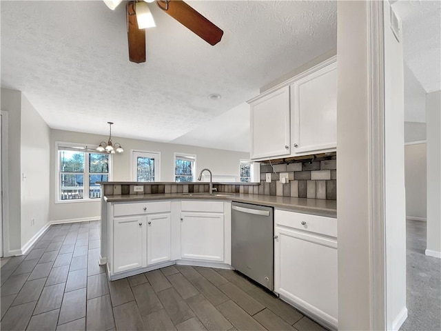 kitchen featuring white cabinetry, sink, stainless steel dishwasher, and kitchen peninsula