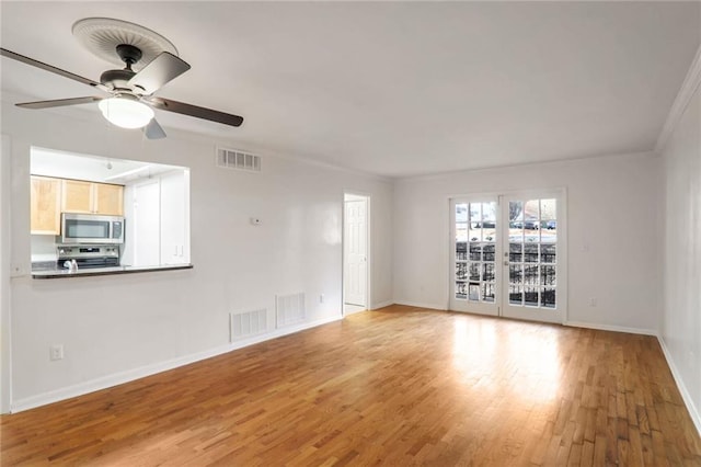 unfurnished living room featuring ceiling fan, ornamental molding, and hardwood / wood-style flooring