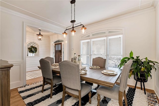 dining room with crown molding and light hardwood / wood-style flooring