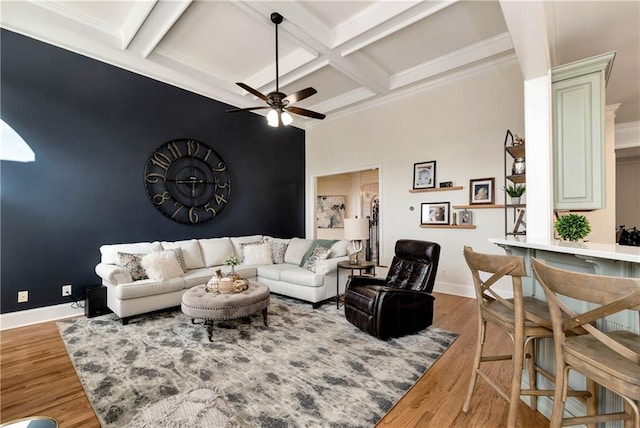 living room featuring beamed ceiling, ceiling fan, wood-type flooring, and coffered ceiling