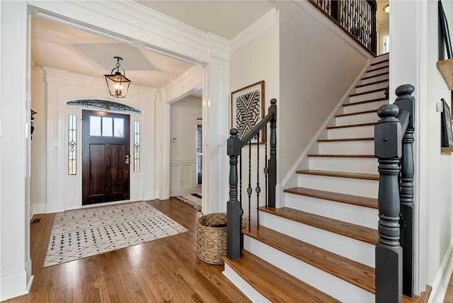 entrance foyer with hardwood / wood-style flooring and crown molding