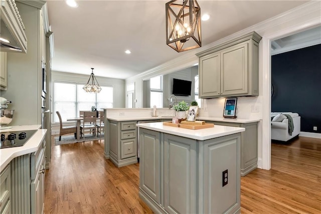 kitchen with a kitchen island, gray cabinetry, hanging light fixtures, light hardwood / wood-style floors, and black electric cooktop