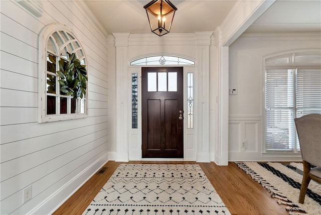 foyer with hardwood / wood-style flooring and ornamental molding