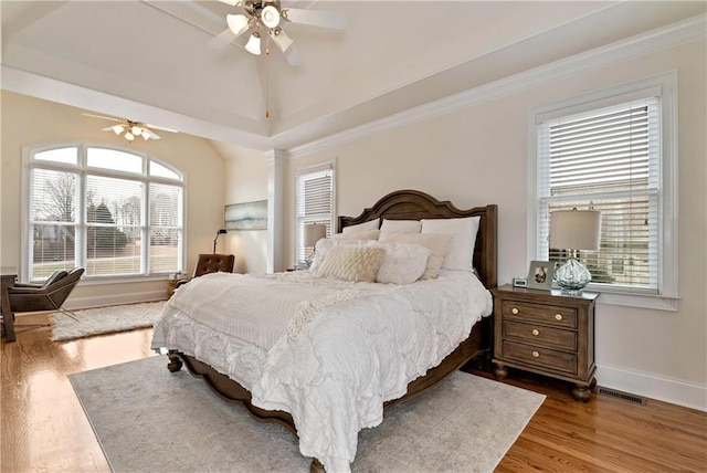 bedroom featuring multiple windows, wood-type flooring, and ceiling fan