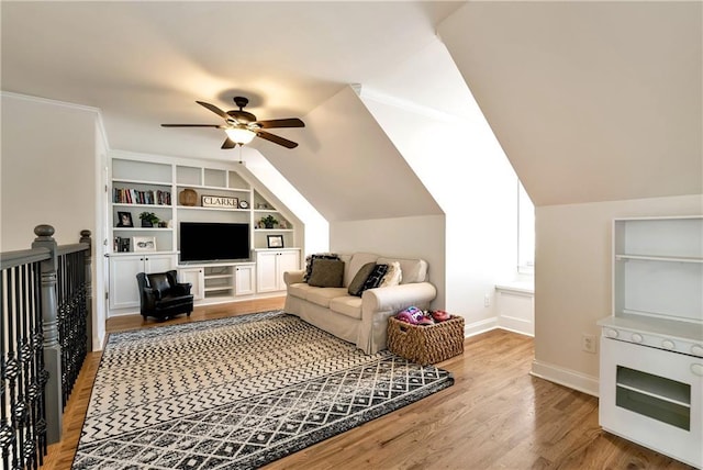 living room featuring built in shelves, ceiling fan, lofted ceiling, and hardwood / wood-style floors