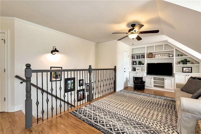 living room with ornamental molding, hardwood / wood-style floors, built in features, and ceiling fan