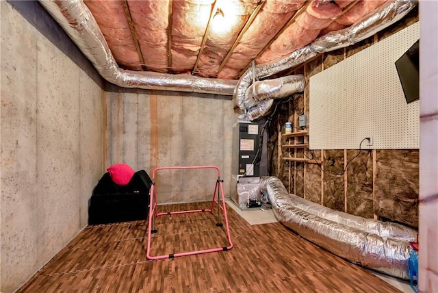 basement with heating unit and wood-type flooring