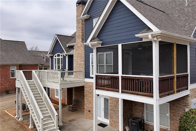 rear view of property with a patio, a sunroom, and central AC unit