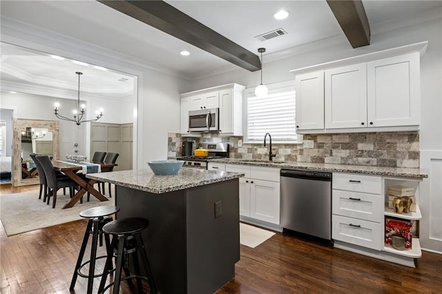 kitchen featuring stainless steel appliances, white cabinetry, a sink, and visible vents