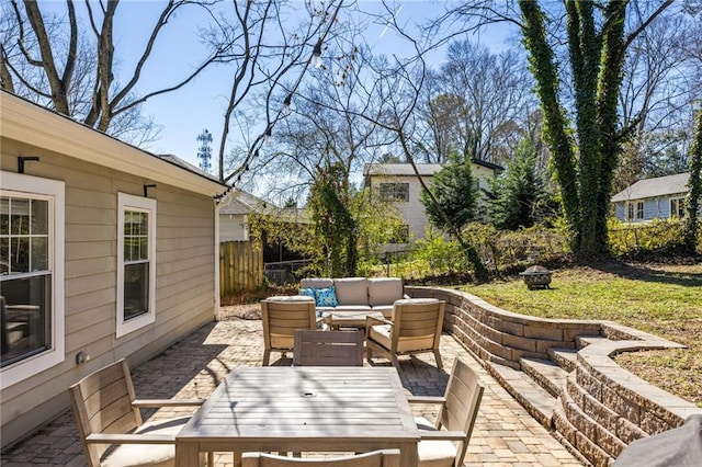 view of patio with an outdoor living space with a fire pit and fence