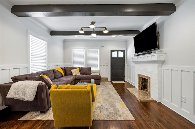 living room featuring a wealth of natural light, dark wood-style flooring, beamed ceiling, and wainscoting