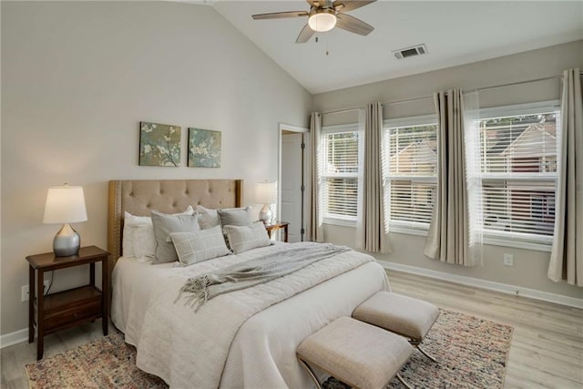 bedroom with visible vents, baseboards, a ceiling fan, light wood-style flooring, and vaulted ceiling