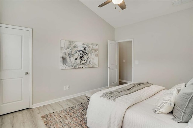 bedroom featuring light wood-style floors, vaulted ceiling, baseboards, and ceiling fan