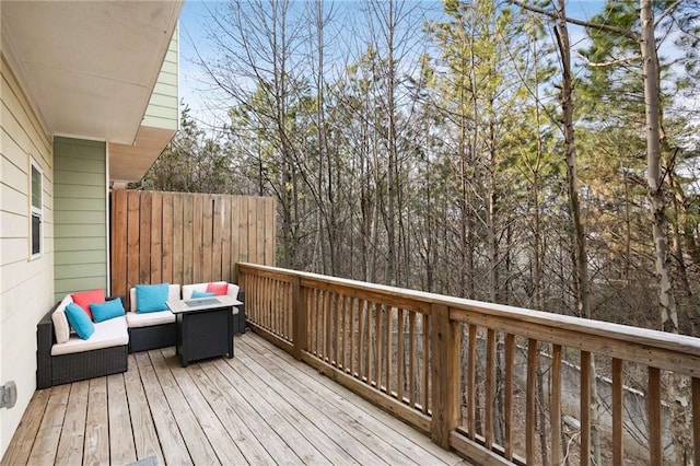 wooden terrace with outdoor lounge area and fence